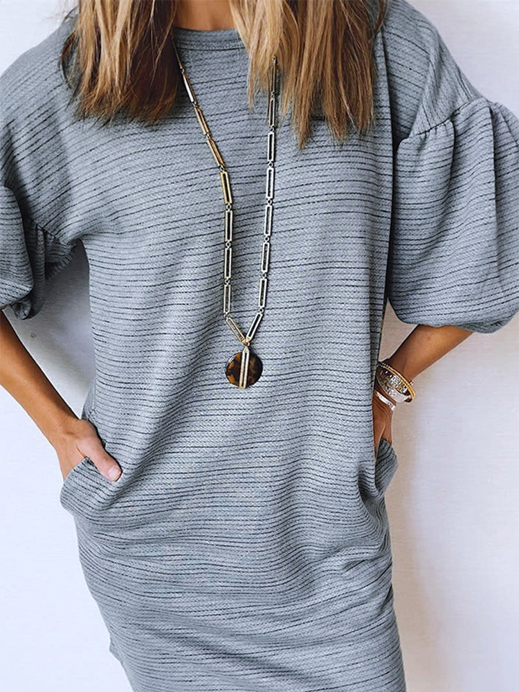 This Grey Pumice - Sweatshirt Dress is a versatile piece that combines the comfort of a pullover sweatshirt with the classy silhouette of a formal dress. With its 3/4 sleeves, it is the perfect balance between casual and formal wear.