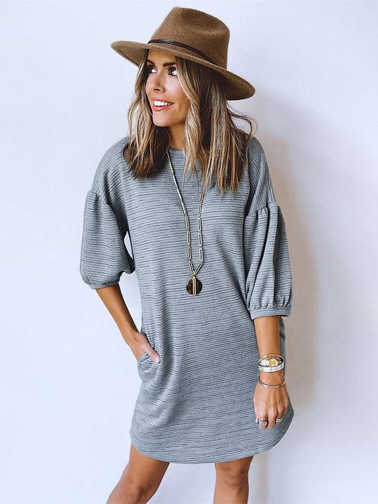 This Grey Pumice - Sweatshirt Dress is a versatile piece that combines the comfort of a pullover sweatshirt with the classy silhouette of a formal dress. With its 3/4 sleeves, it is the perfect balance between casual and formal wear.