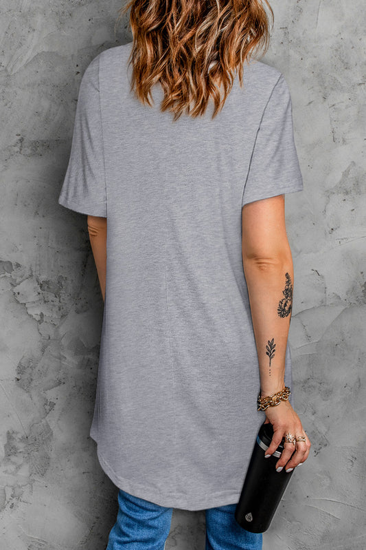 This short sleeve tunic top boasts a casual and loose fit, complete with functional pockets for added convenience. Crafted with a simple and versatile design, it's perfect for everyday wear.