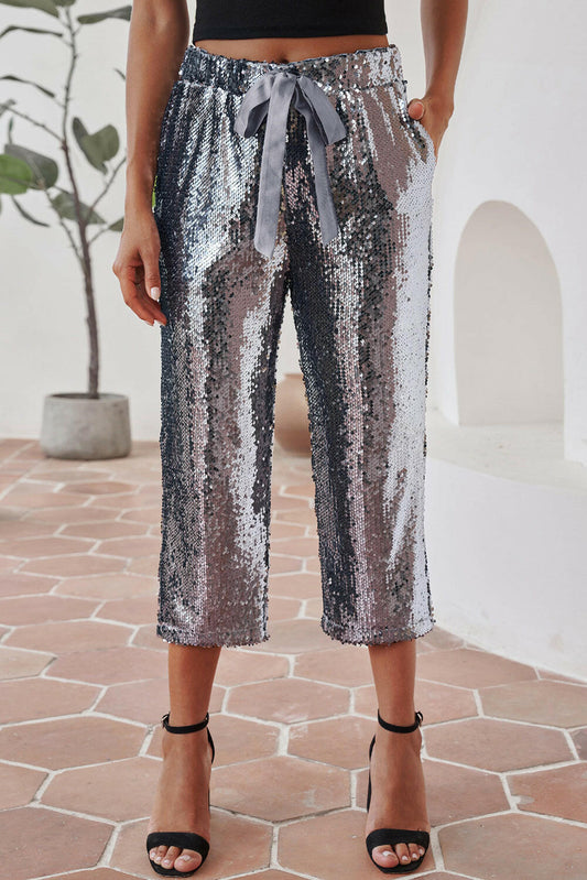 Crafted with a drawstring closure, these cropped sequin pants add a touch of shimmer to any outfit - perfect for formal, business, or casual occasions. Made with a high waist design for a stylish and versatile look.