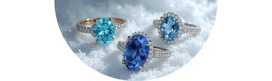 Snowy outdoor display of raw and faceted December birthstones including turquoise, tanzanite, and blue zircon—Demali&RiverCo.