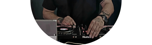 Close-up of a Wedding DJ with tattoos and Demali&RiverCo jewelry at a wedding reception playlist event.