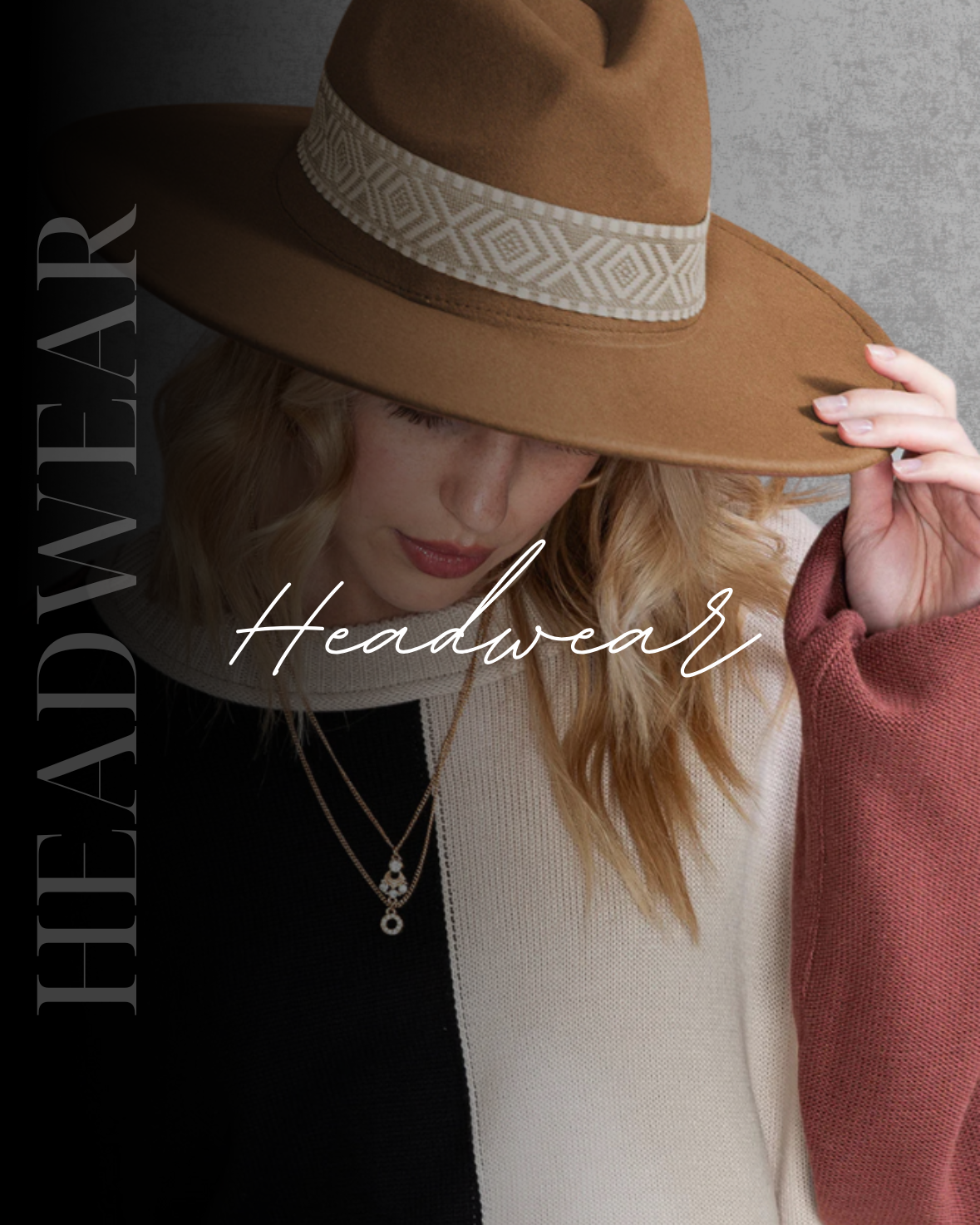 A woman wearing a stylish wide-brimmed straw hat at the beach.