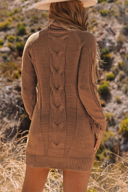 The Rustic Charm - Sweater Dress features a high-neck, short design with a twist fringe detail, boasting a warm and rustic brown color.